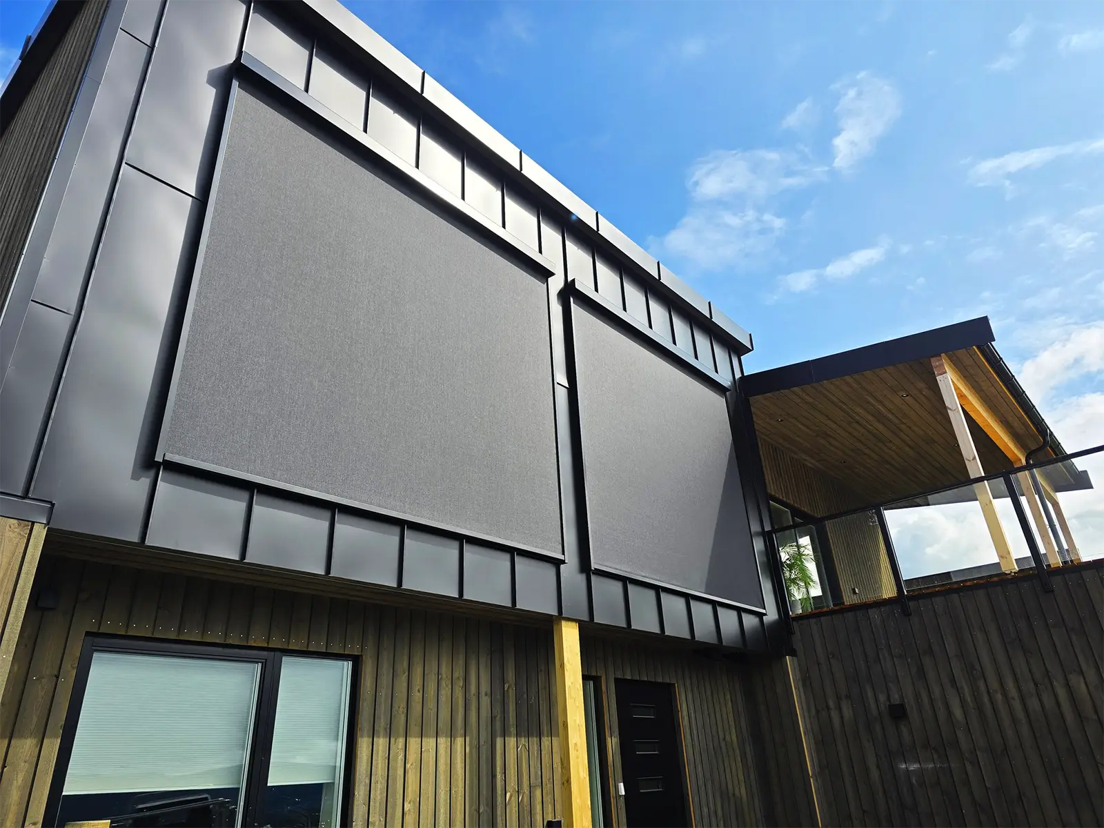 Moderne hus med effektive utvendige screens over store vinduer