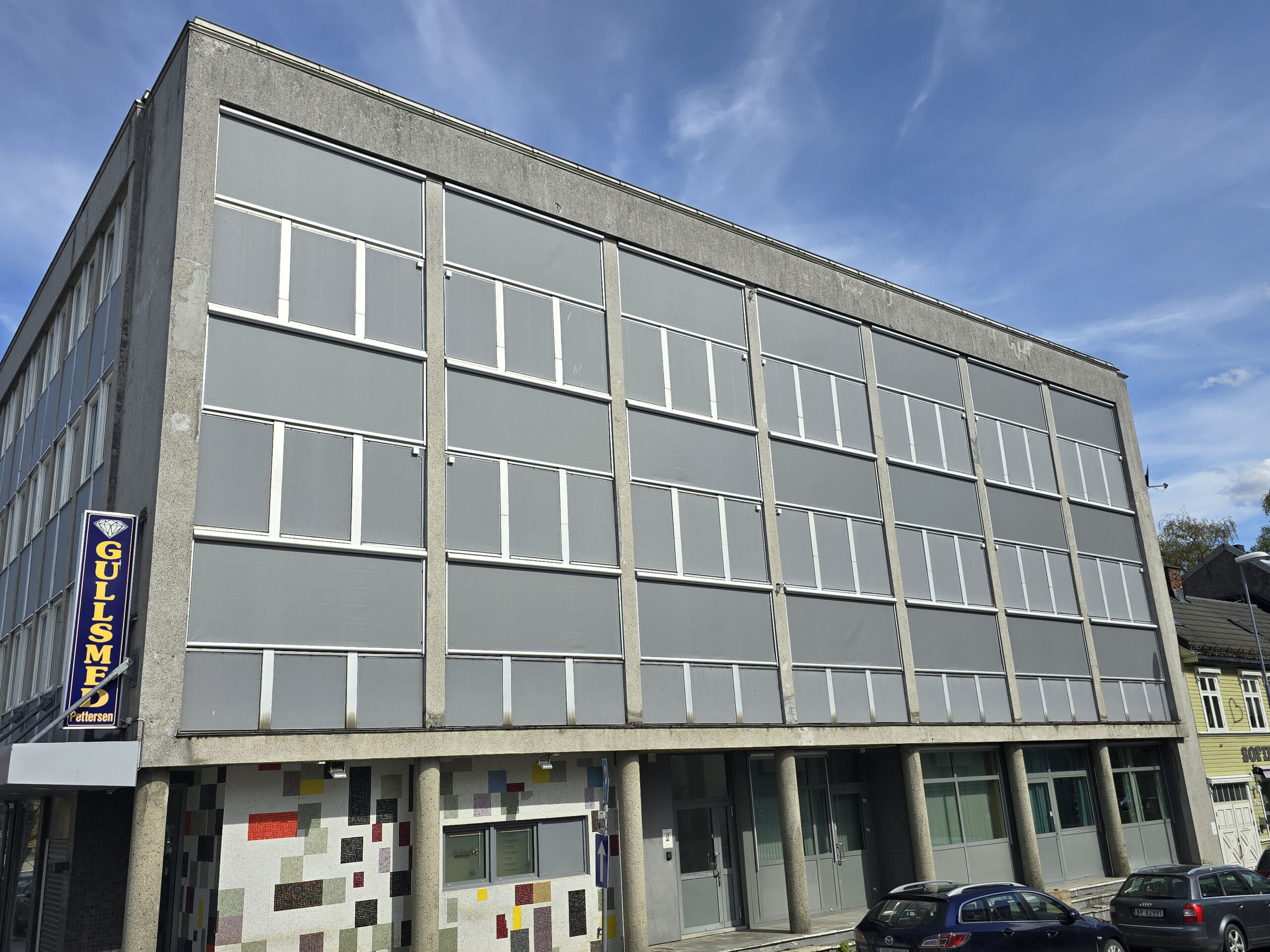 Moderne boligblokk med integrert solskjerming via utvendige screens